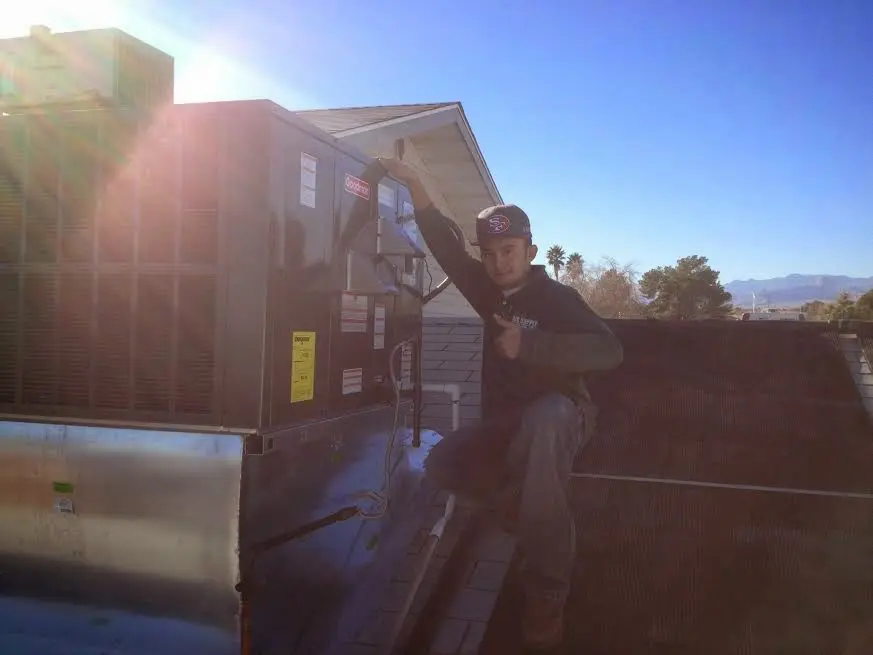 HVAC technician performing HVAC Inspection on a rooftop unit in San Carlos Park